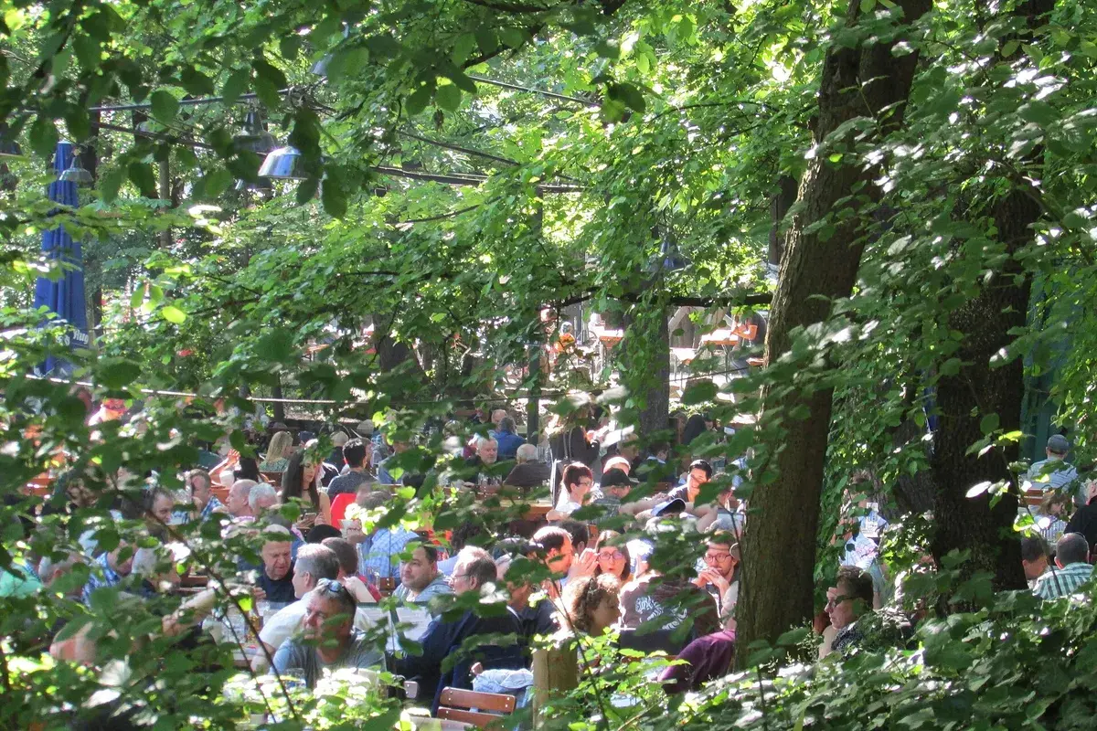 Tische unter schattigen Bäumen in einem Augustiner-Biergarten. Foto: Chris Light