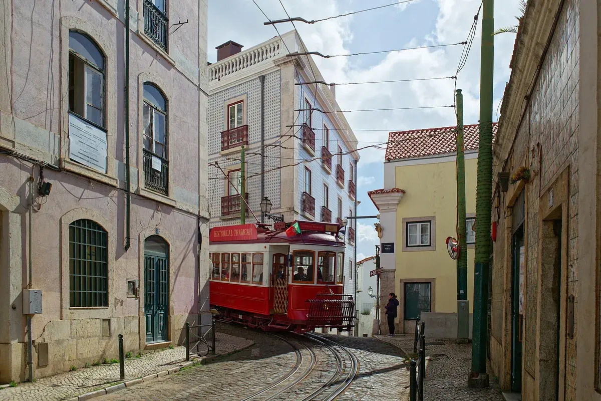 A tram winds through Alfama's narrow streets, one of Lisbon's most atmospheric neighbourhoods to stay in. Photo: madras91, CC BY 2.0