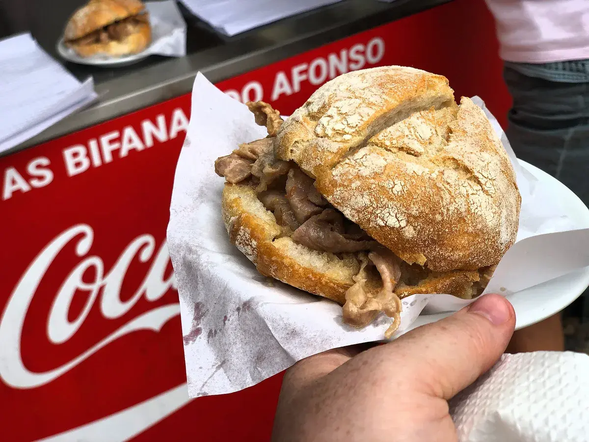 A bifana, pork in a soft roll, held fresh from the counter. Photo: Sonse, CC BY 2.0