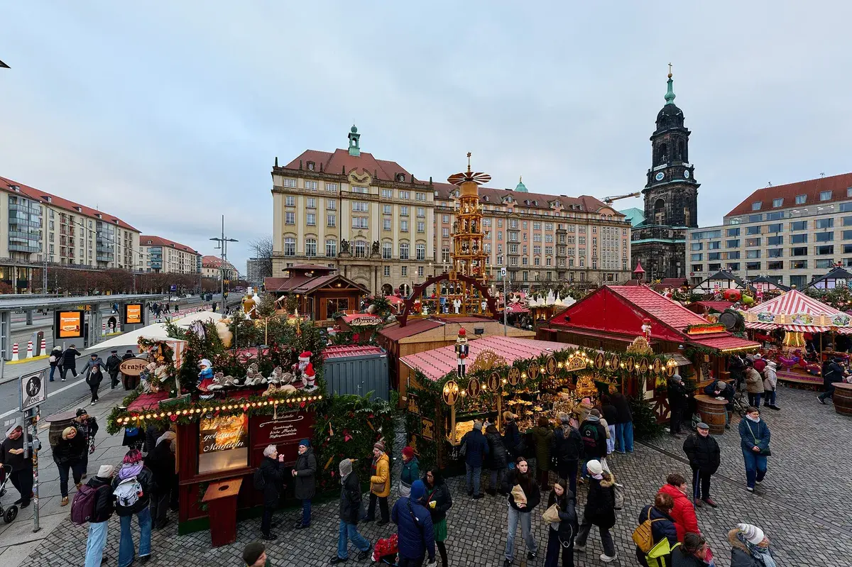 Stalls and visitors on the Altmarkt at the Dresden Striezelmarkt, with the Kreuzkirche tower behind. Photo: Leonhard Lenz, CC0