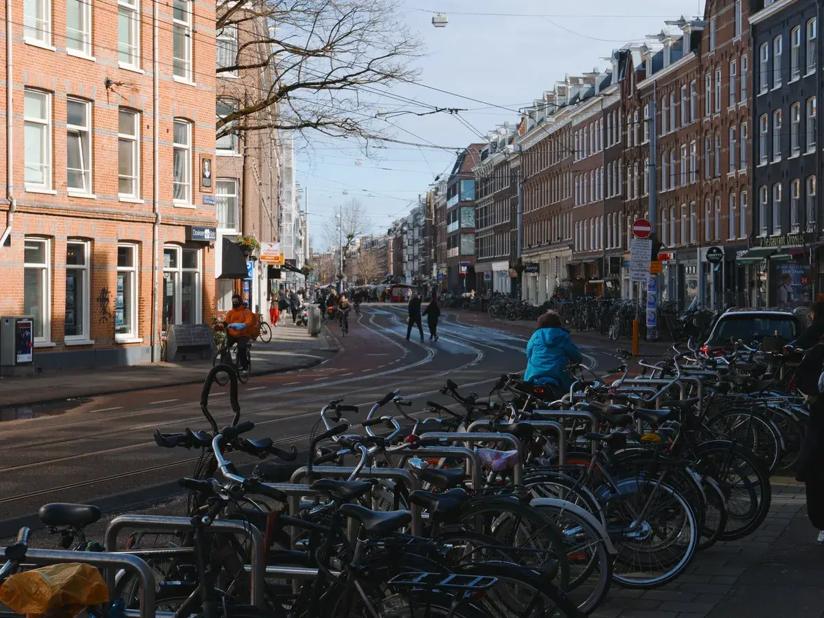 Rows of parked bicycles line Albert Cuypstraat in De Pijp on a sunny day. Photo: Fons Heijnsbroek, CC0