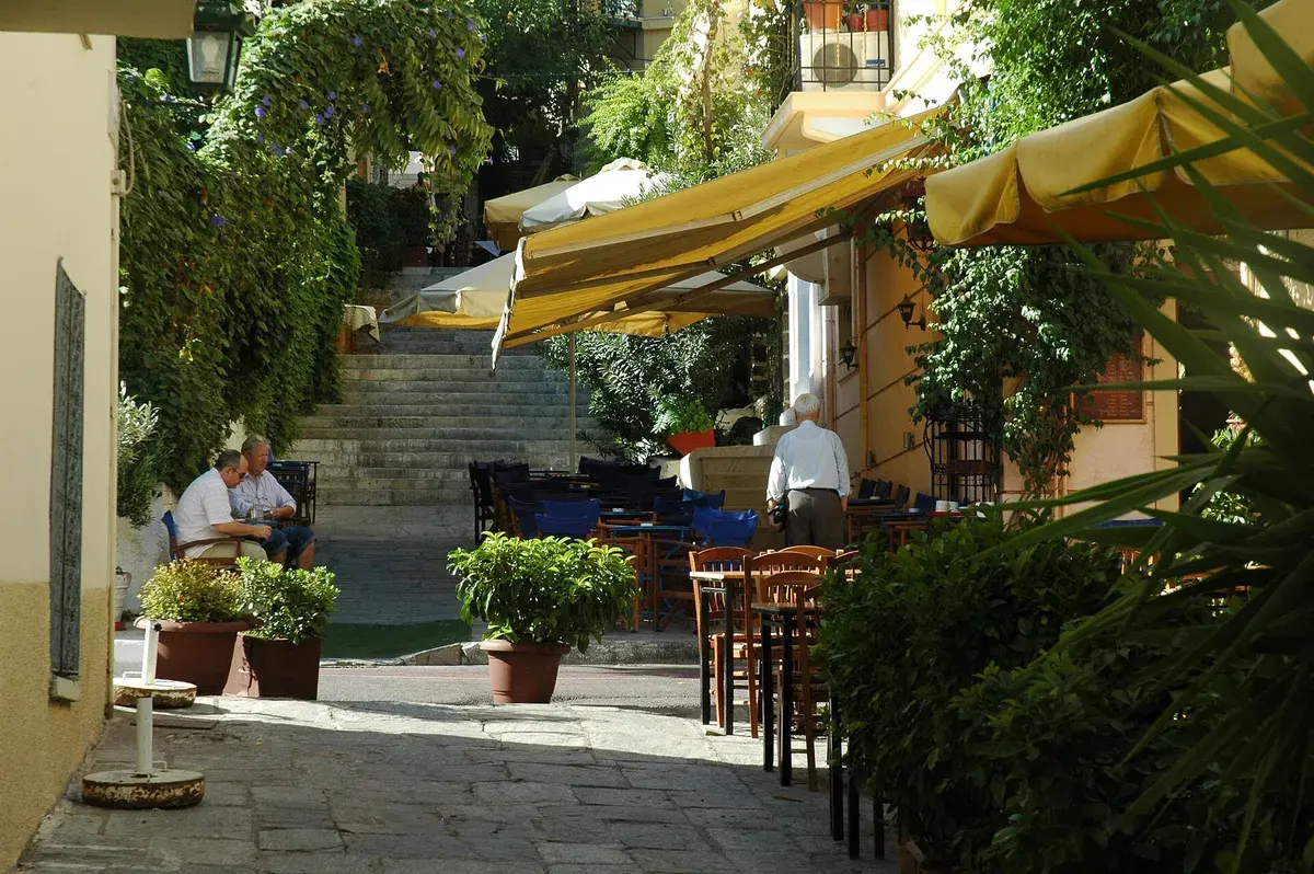 Restaurant tables line a side street in Plaka, where menu boards are worth reading before you sit. Photo: Jpatokal, CC BY-SA 4.0